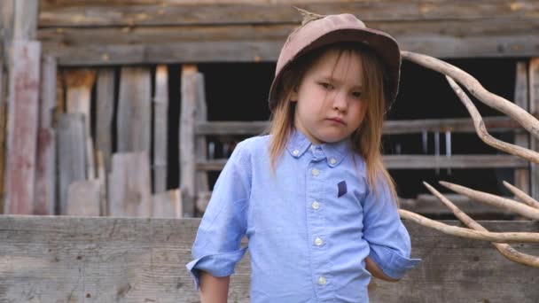 Niña seria en ropa azul y un casco polvoriento edificio viejo — Vídeos de Stock