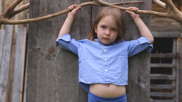 Πορτρέτο του ένα όμορφο κοριτσάκι με μπλε ρούχα που παρουσιάζουν — Αρχείο Βίντεο