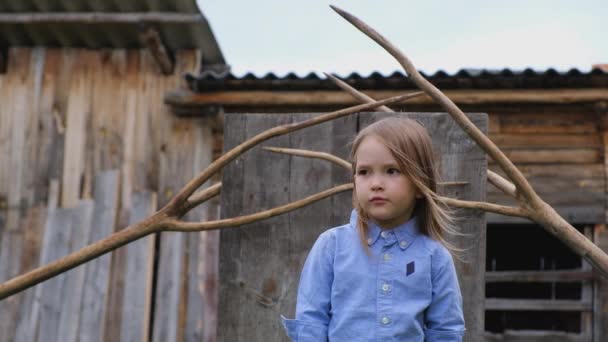 Linda niña posando sobre el fondo de accesorios de madera inusuales — Vídeos de Stock
