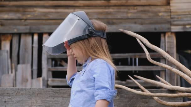 Menina na camisa coloca um capacete protetor sonhando com a futura profissão Vídeo De Stock