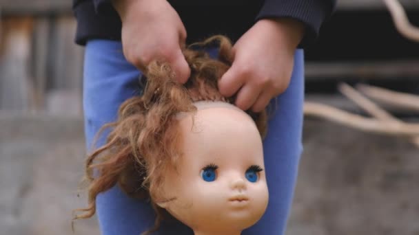 Girl scaredly hold in their hands the old disheveled doll Royalty Free Stock Footage