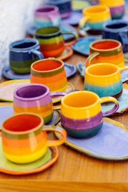 colorful ceramic cups on wooden table retale outdoors
