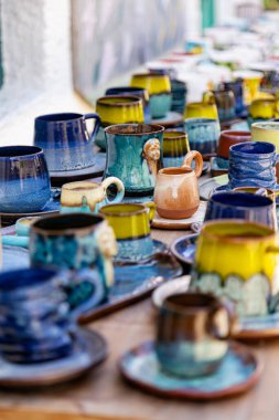 colorful ceramic cups on wooden table retale outdoors