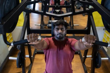 Genç bir adamın portresi. Spor salonunda egzersiz yapan genç bir adam. Artı boyut 