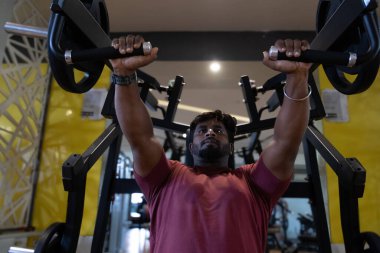 Genç bir adamın portresi. Spor salonunda egzersiz yapan genç bir adam. Artı boyut 