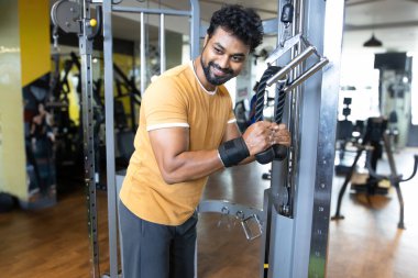 Genç bir adamın portresi. Spor salonunda egzersiz yapan genç bir adam. Artı boyut 