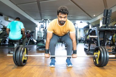 Spor salonunda ağırlık kaldırma. Genç bir adamın portresi. Genç 