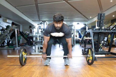 Spor salonunda ağırlık kaldırma. Genç bir adamın portresi. Genç 