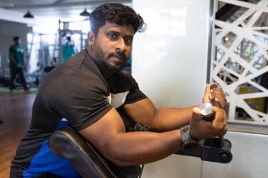 Genç bir adamın portresi. Spor salonunda egzersiz yapan genç bir adam. Artı boyut 