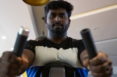 Genç bir adamın portresi. Spor salonunda egzersiz yapan genç bir adam. Artı boyut 