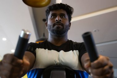 Genç bir adamın portresi. Spor salonunda egzersiz yapan genç bir adam. Artı boyut 