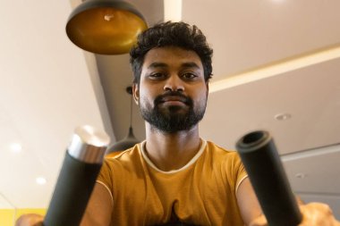 Genç bir adamın portresi. Spor salonunda egzersiz yapan genç bir adam. Artı boyut 