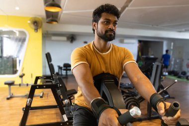 Genç bir adamın portresi. Spor salonunda egzersiz yapan genç bir adam. Artı boyut 