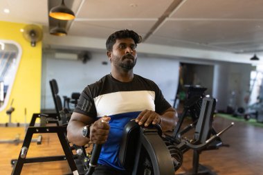 Genç bir adamın portresi. Spor salonunda egzersiz yapan genç bir adam. Artı boyut 