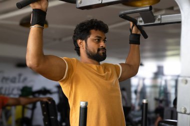 Genç bir adamın portresi. Spor salonunda egzersiz yapan genç bir adam. Artı boyut 