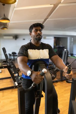 Genç bir adamın portresi. Spor salonunda egzersiz yapan genç bir adam. Artı boyut 