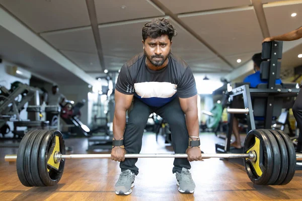 Spor salonunda ağırlık kaldırma. Genç bir adamın portresi. Genç 