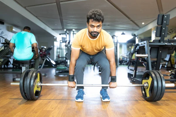 Spor salonunda ağırlık kaldırma. Genç bir adamın portresi. Genç 