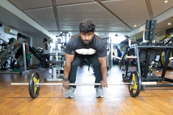 Spor salonunda ağırlık kaldırma. Genç bir adamın portresi. Genç 