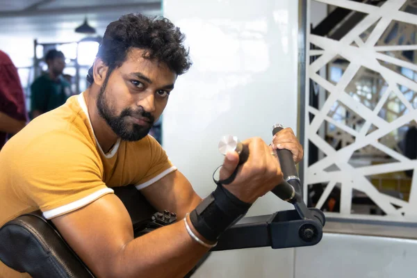 Genç bir adamın portresi. Spor salonunda egzersiz yapan genç bir adam. Artı boyut 