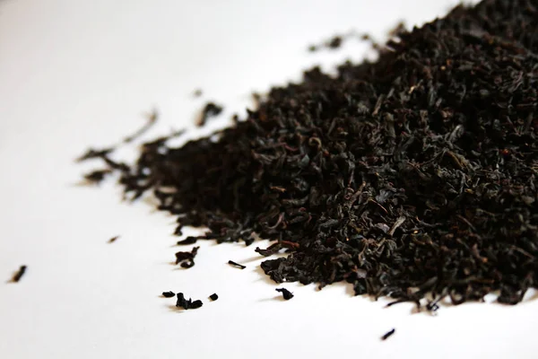 A bunch of black dried tea leaves on the white table