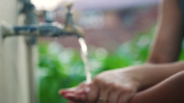 Donna che tiene e lava la mano della figlia sotto un rubinetto — Video Stock