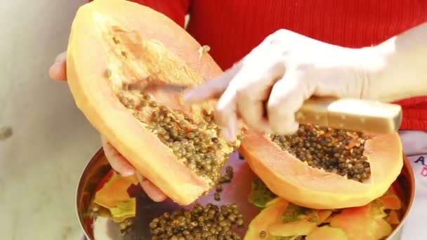 Hände eines indischen Mannes, der Papaya schneidet. — Stockvideo