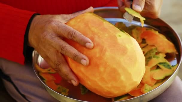 Die reife Papaya mit einem scharfen Messer schälen — Stockvideo