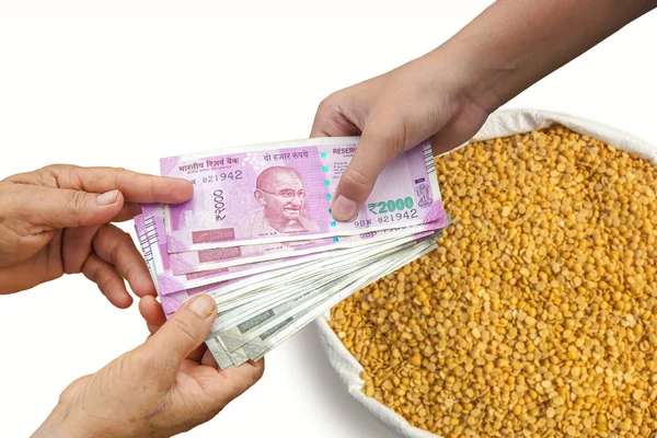 Indian cash money changing hands between a buyer and farmer
