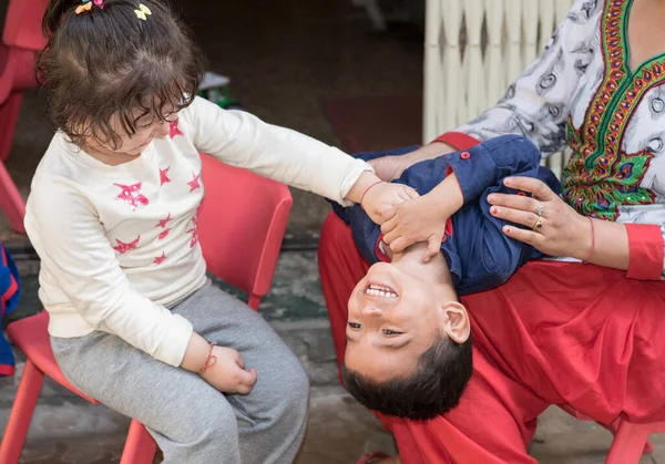 Çocuklar evde eğleniyor, gıdıklanıyor ve kıkırdıyor, dışarıda mutlu bir aile..