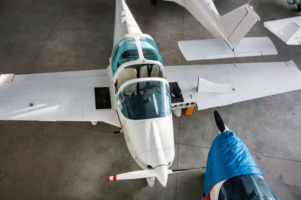 Top view of small sports airplanes in a hangar