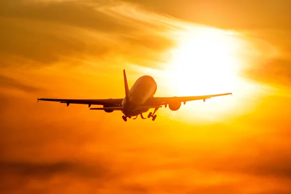 Take-off of a passenger airplane directly to the rising morning sun