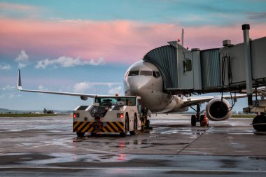 Jet köprüsünde yolcu uçak ve çekici kamyon. Önden görünüm