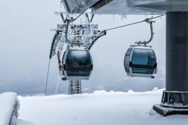 Gondola lifts on top of the mountain in winter clipart