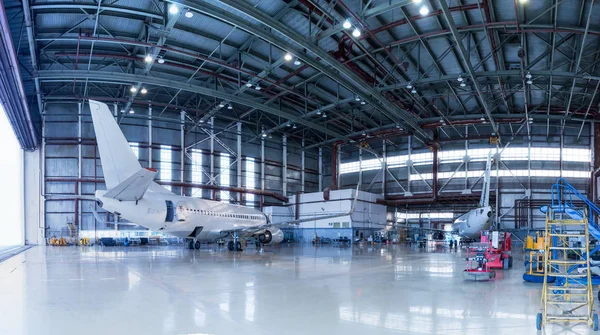 Bakım altında yolcu uçakları. Uçuş operasyonları için mekanik sistemlerin kontrol edilmesi. Hangar içinde uçak Panoraması