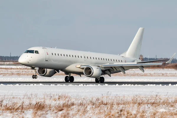 Lądowanie Białego Samolotu Pasażerskiego Odrzutowca Pasie Startowym Zimowego Portu Lotniczego — Zdjęcie stockowe
