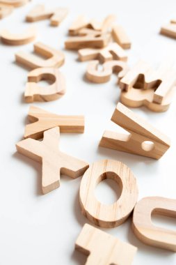 Öğrenme ve dekorasyon için beyaz yüzeye dağılmış ahşap alfabe harfleri. Yüksek kalite.