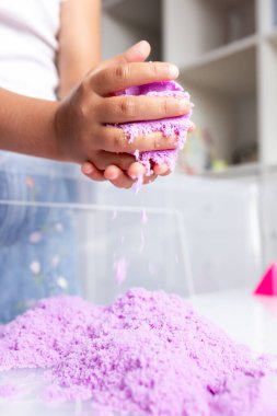 Çocuk içeride mor kinetik kumla oynuyor. Yüksek kalite.