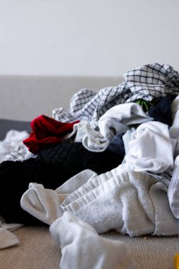 Kanepeye karışık çamaşır yığını. Havlular ve giysiler de dahil. Yüksek kalite.