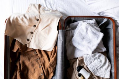 Seyahat için günlük giysiler ve tuvalet malzemeleriyle dolu bavulu aç. Yüksek kalite.