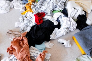 Pile of colorful laundry on beige sofa. High quality.