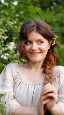 Kırsalda yasemin çiçekleriyle poz veren eski püskü elbiseli güzel bir kadın.