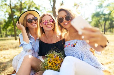 Eğlence Parkı ve yapmak selfie üç güzel kız orgazm. Mükemmel güneşli havalarda. Güzel resimler. Süper ruh hali. Yaz konsepti.
