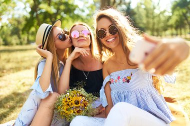 Eğlence Parkı ve yapmak selfie üç güzel kız orgazm. Mükemmel güneşli havalarda. Güzel resimler. Süper ruh hali. Yaz konsepti.