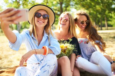 Eğlence Parkı ve yapmak selfie üç güzel kız orgazm. Mükemmel güneşli havalarda. Güzel resimler. Süper ruh hali. Yaz konsepti.