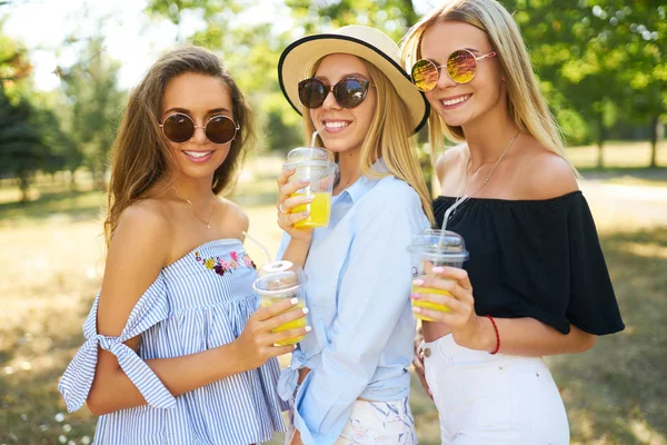 Três Raparigas Simpáticas Divertir Beber Sumo Amarelo Parque Excelente Clima — Fotografia de Stock