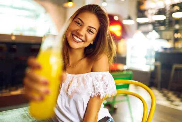 Joven Chica Agradable Divirtiéndose Café Sosteniendo Botella Jugo Naranja Fresco — Foto de Stock