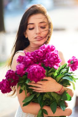 Bahar / yaz stili. Pions bir buket ile bir güzel bahar içinde güzel genç esmer kadın. Güzel Spring Sokağı. Moda bahar yaz fotoğraf.