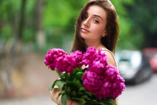 Spring / Summer Style. Beautiful Young Brunette Woman In A Nice Spring Dress With A Bouquet Of Pions. Beautiful Spring Street. Fashion Spring Summer Photo.