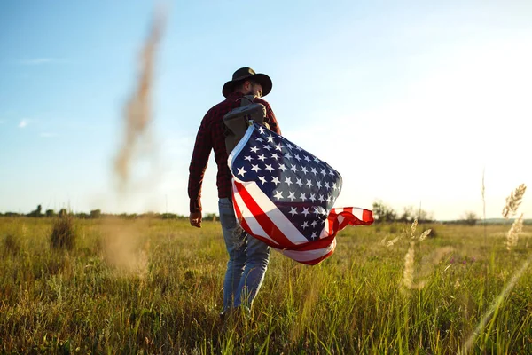 アメリカの Flag Patriotic の休日 アメリカの国旗を持つ旅行者 リュック シャツとジーンズを着ています 美しい夕日の光 アメリカン スタイル — ストック写真